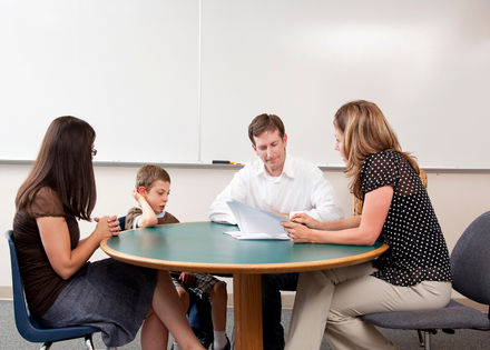 Parents and child talking to teacher